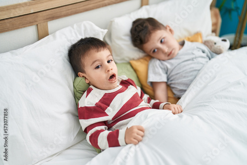 Two kids lying on bed at bedroom