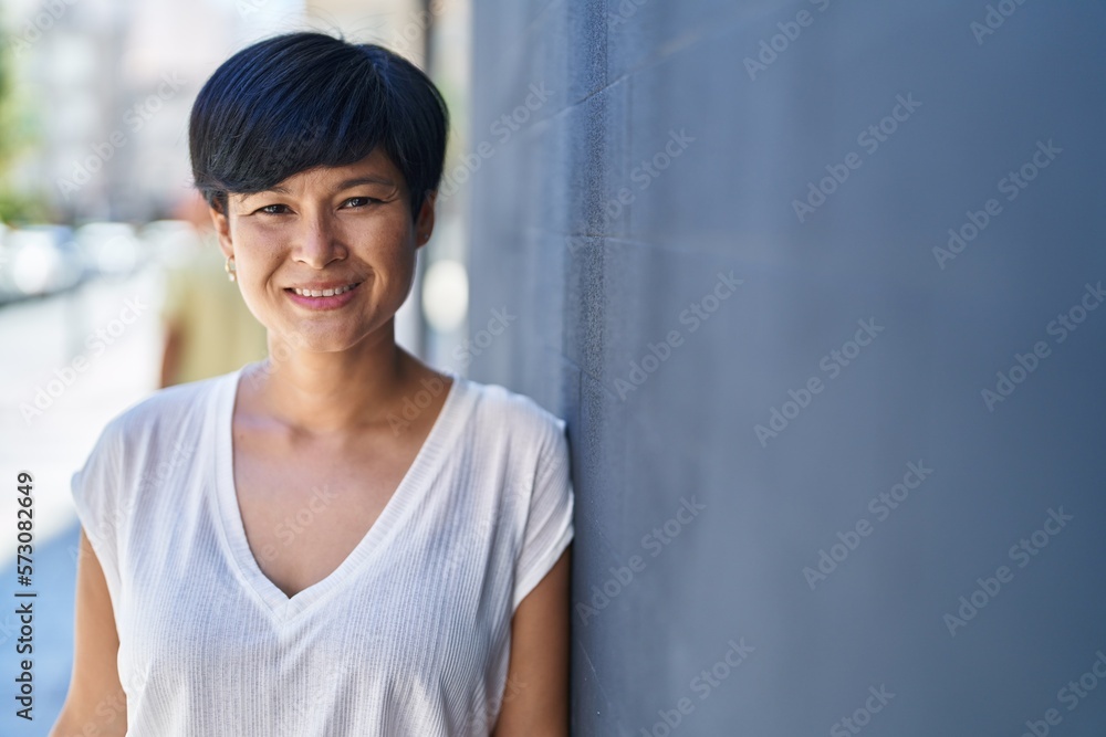 Middle age chinese woman smiling confident standing at street