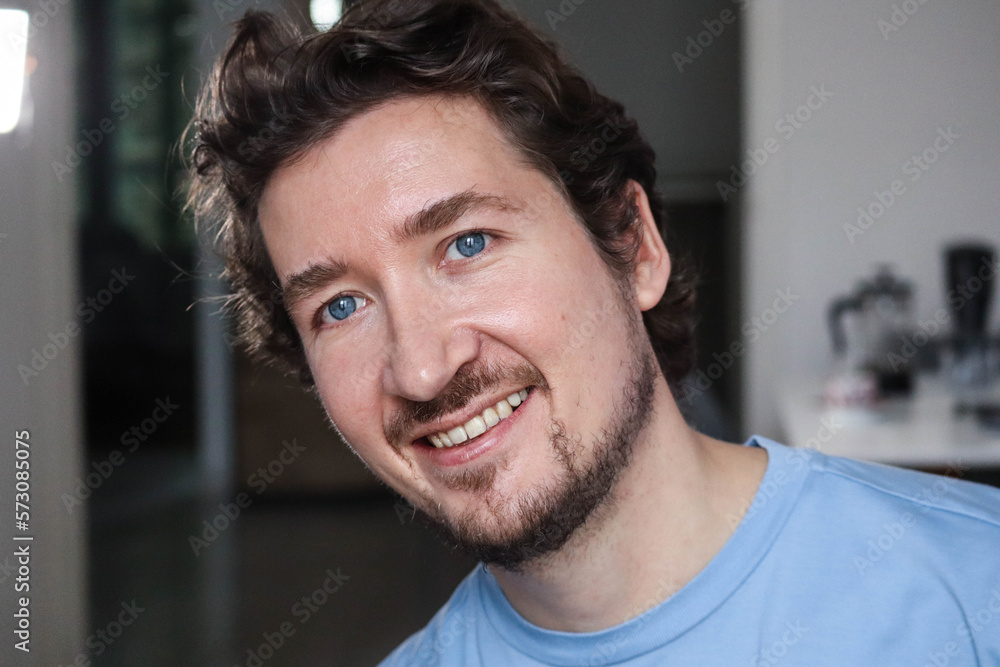 Handsome young man with blue eyes and wavy hair smiling Handsome young man with blue eyes and wavy hair smiling