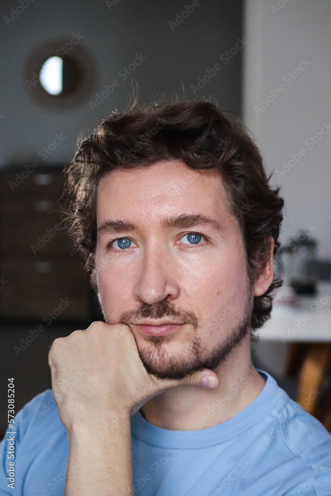 Fototapeta premium Handsome young man with blue eyes and curly wavy hair