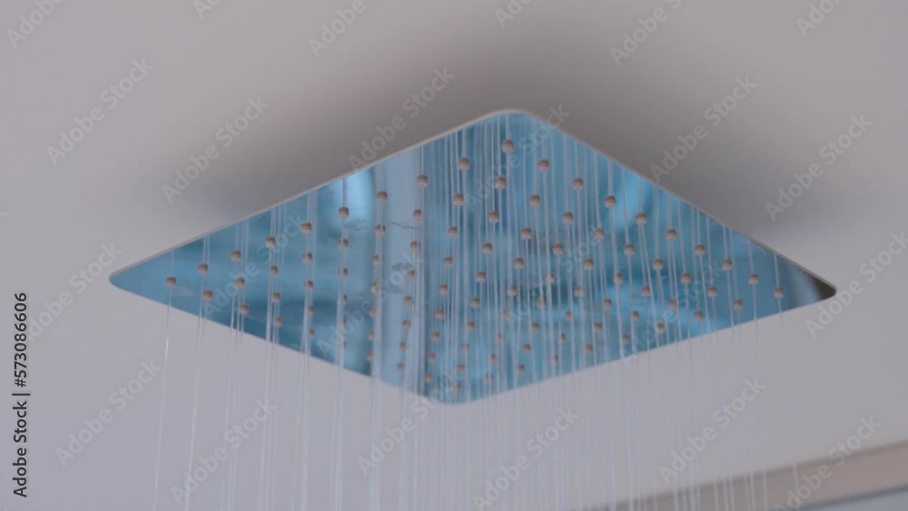 Water flows from the tropical shower. Large water consumption. Chrome large shower head, modern
