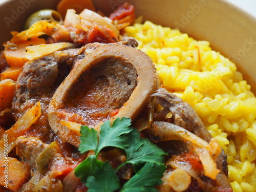 Italian Osso Buco alla Milanese : veal shank stew and safran risotto, closeup on the bone