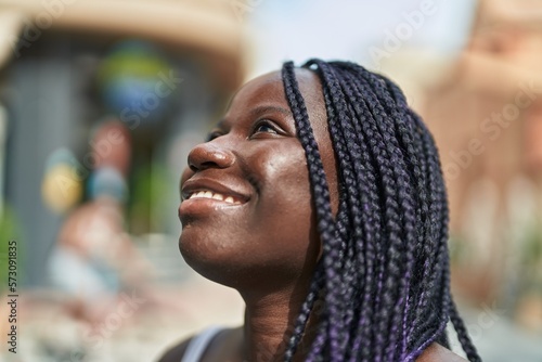 African american woman smiling confident looking to the sky at street