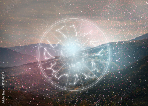 Zodiac wheel with 12 astrological signs and star constellations and mountain landscape on background photo