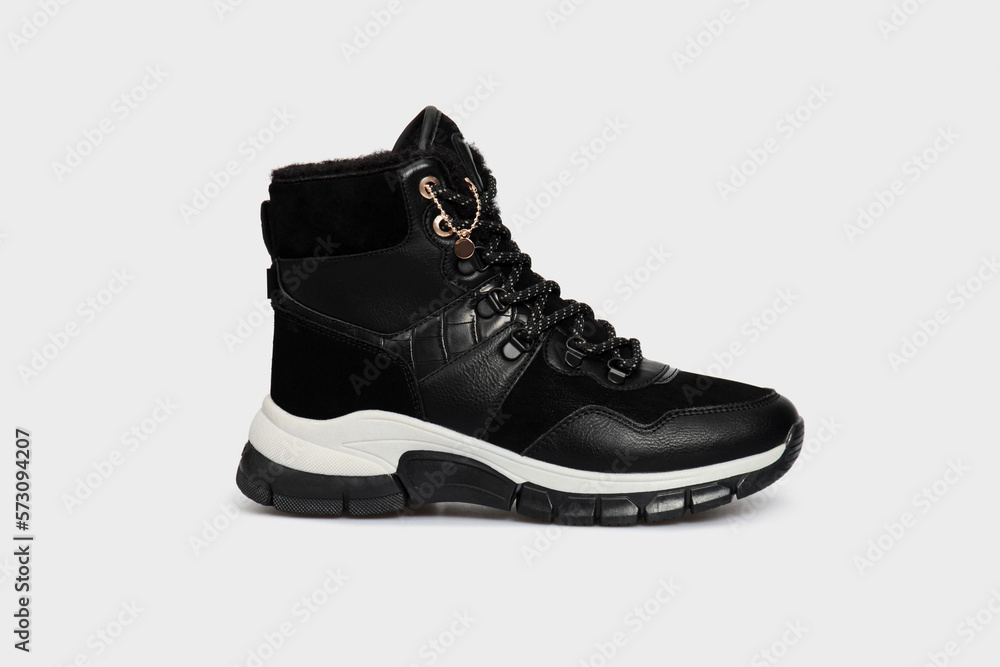 Black women's fashion snake skin leather winter boot shoe isolated on white background. Female luxury footwear in animal print with fur. Single Black women's fashion snake skin leather winter boot shoe isolated on white background. Female luxury footwear in animal print with fur. Single