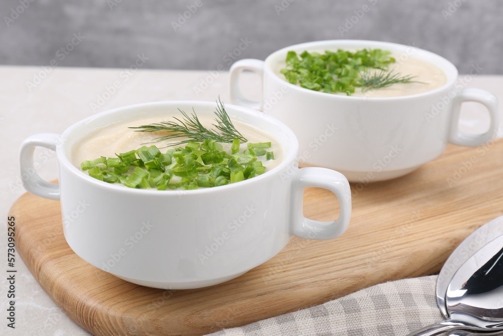Bowls with tasty creamy soup of parsnip on light grey table, closeup Bowls with tasty creamy soup of parsnip on light grey table, closeup