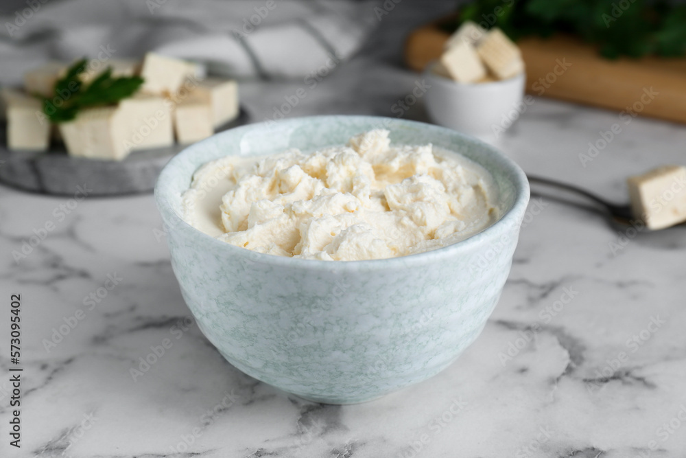Delicious tofu cream cheese in bowl on white marble table, closeup Delicious tofu cream cheese in bowl on white marble table, closeup
