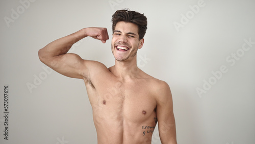 Young hispanic man smiling confident doing strong gesture with arm over isolated white background