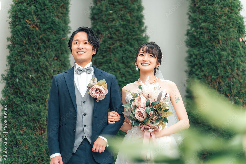 結婚式で結婚式場の庭でブーケを持つ新郎新婦（ガーデン 