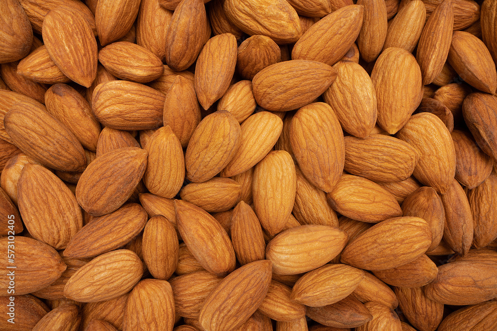 Beautiful pile of big raw peeled almonds laying in the background. which is a view close to the object. Shot with a sharp macro lens. Healthy food concept. Beautiful pile of big raw peeled almonds laying in the background. which is a view close to the object. Shot with a sharp macro lens. Healthy food concept.