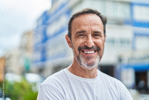 Middle age man smiling confident standing at street