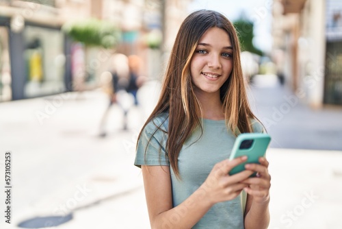 Adorable girl smiling confident using smartphone at street