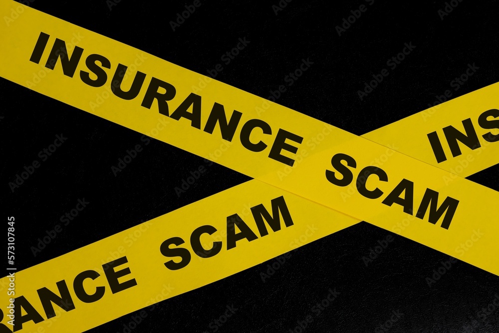 Insurance scam and fraud alert, caution and warning concept. Yellow barricade tape with word in dark black background.