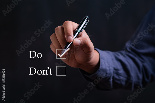 businessman Hand holding pen and choose word do or dont. Personal development and career growth or change yourself concept.