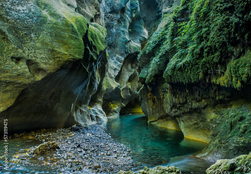 The turquoise water of the river flowing the lichen and moss covered chasm walls in the beautiful  Patuna Chasm photo