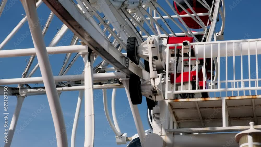 Large rubber wheels of Ferris wheel attraction in park. mechanism of operation is spinning Ferris wheel. Details of carousel in amusement park. Large rubber wheels of Ferris wheel attraction in park. mechanism of operation is spinning Ferris wheel. Details of carousel in amusement park.