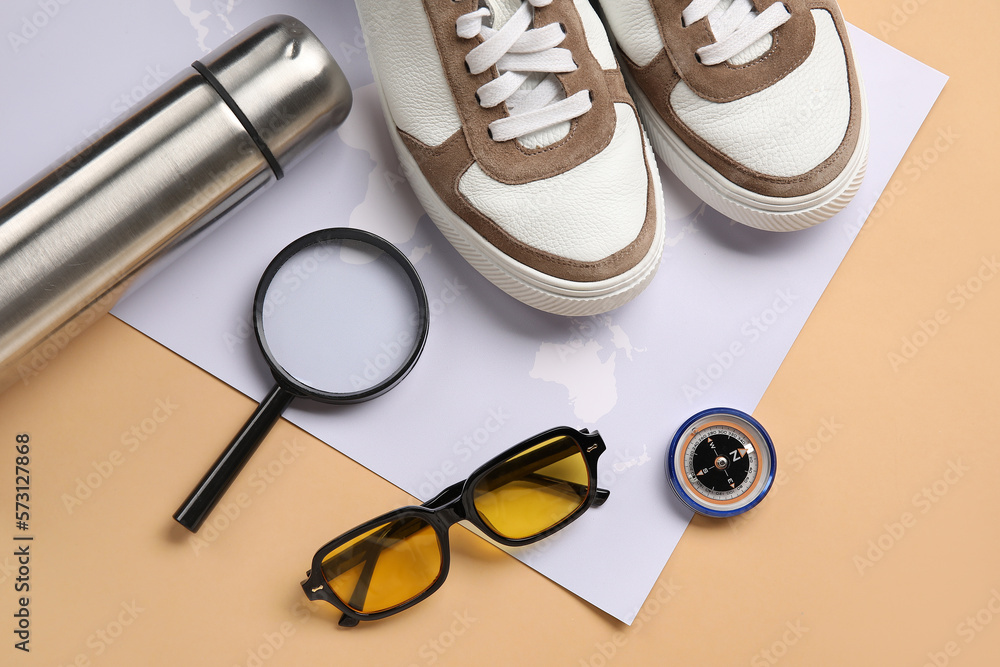 Compass with traveler accessories on beige background Compass with traveler accessories on beige background