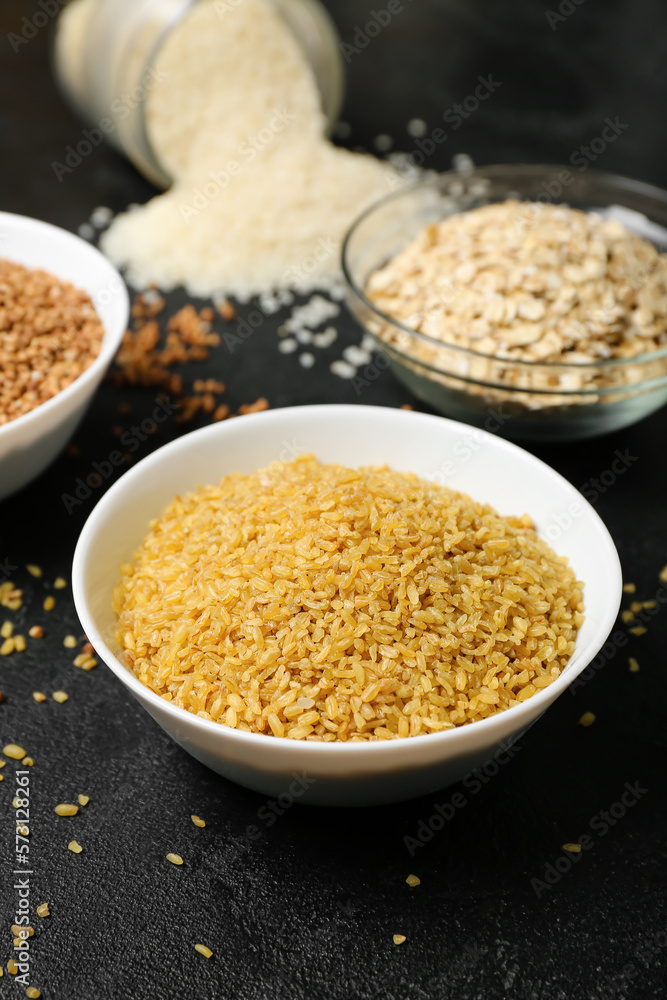 Bowl of raw bulgur on dark background, closeup Bowl of raw bulgur on dark background, closeup