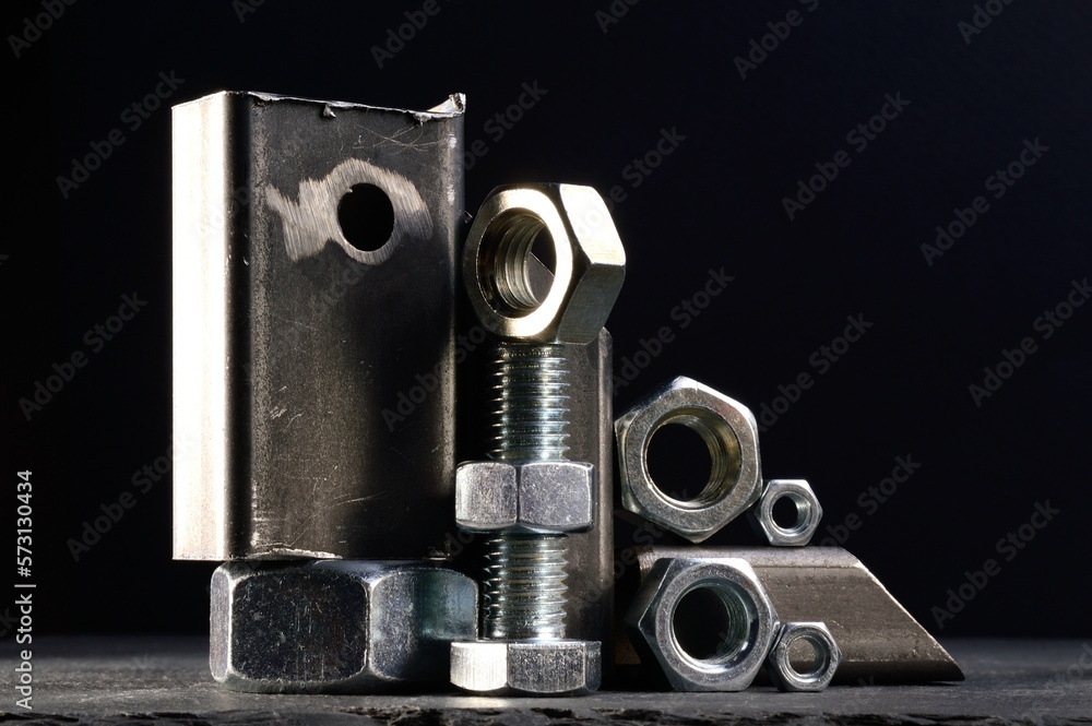 composition of nuts bolts and scraps of metal laid out on a dark background. composition of nuts bolts and scraps of metal laid out on a dark background.