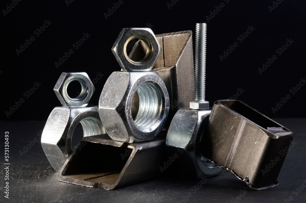 composition of nuts bolts and scraps of metal laid out on a dark background. composition of nuts bolts and scraps of metal laid out on a dark background.