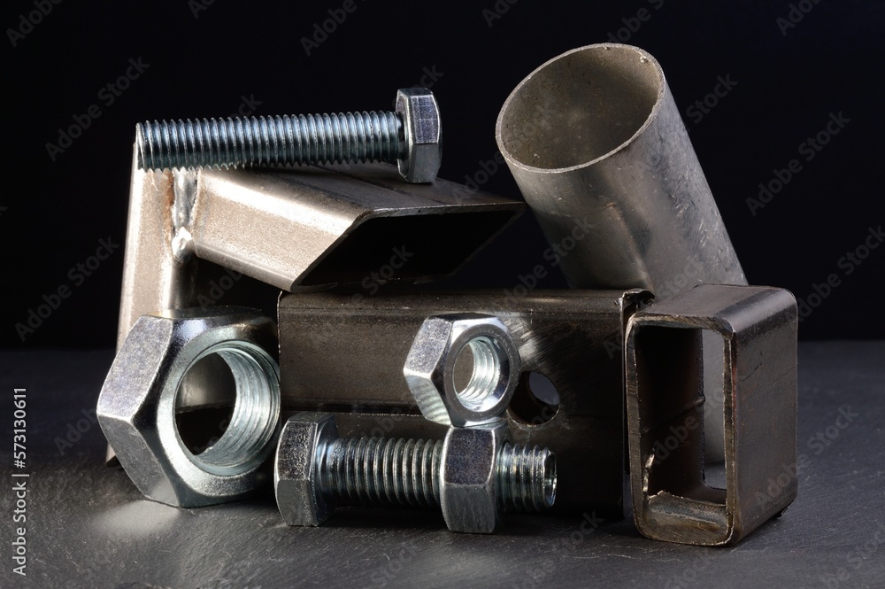 composition of nuts bolts and scraps of metal laid out on a dark background. composition of nuts bolts and scraps of metal laid out on a dark background.
