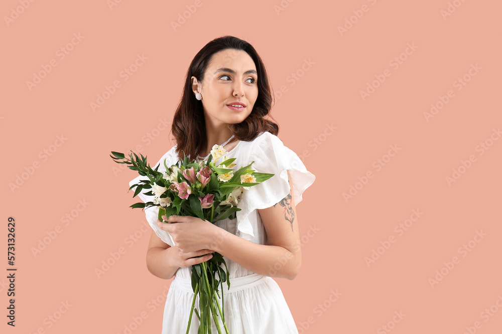 Young woman in dress with alstroemeria flowers on pink background Young woman in dress with alstroemeria flowers on pink background