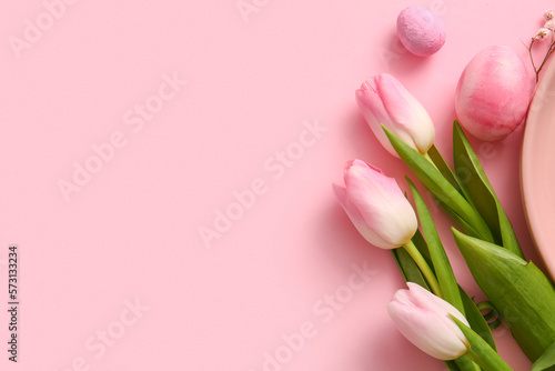 Beautiful tulip flowers and painted Easter eggs on pink background