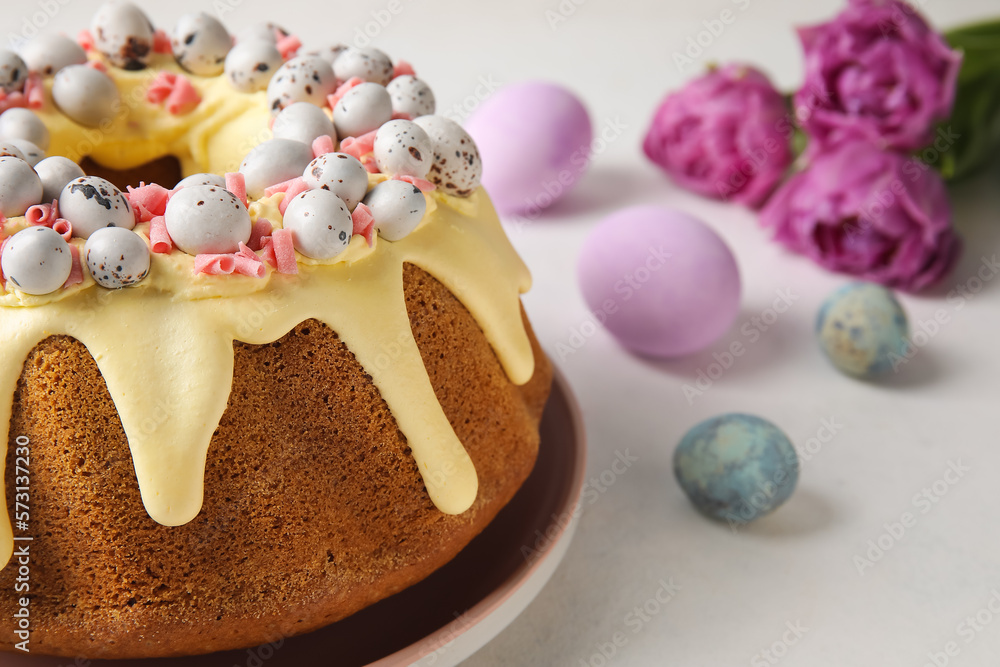 Tasty Easter cake, eggs and tulip flowers on light background, closeup Tasty Easter cake, eggs and tulip flowers on light background, closeup