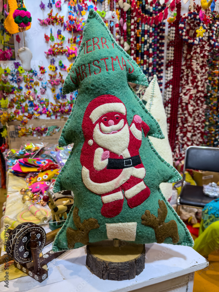 Christmas holidays, Green christmas tree made with clothes and santa clause printed on it with colorful background.
