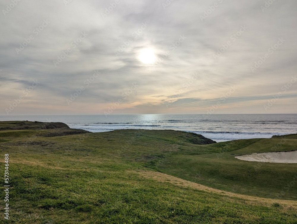 Fototapeta premium sunset over the Pacific Ocean, sunset in Half Moon Bay State Beach cliff side landscape