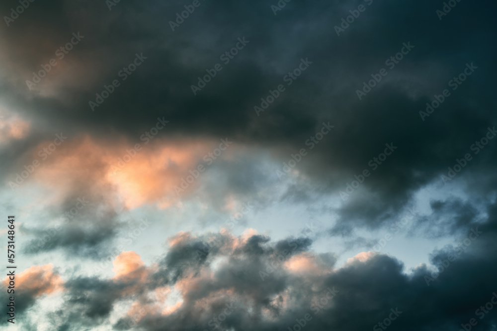 Cumulus sunset clouds with the sun setting down. Amazing sky summer evening background.