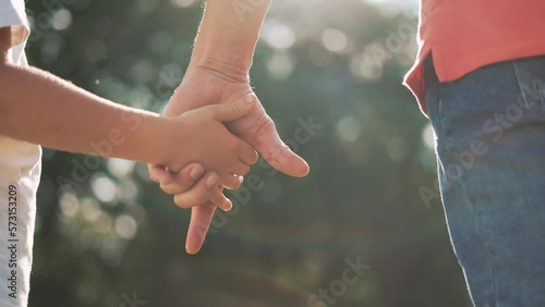 happy family father and daughter hold hands close up. Dad and baby girl hands together at sunset. Father Day. Dad and daughter are holding hands. A father extended a helping hand to his daughter child