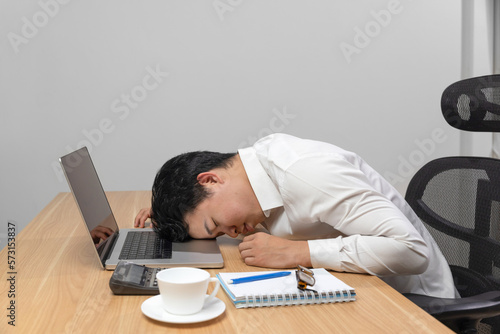 Man with narcolepsy is fall asleep on office desk..Narcolepsy is a sleep disorder that makes people very drowsy during the day.  photo