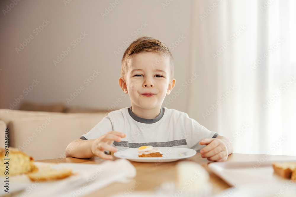 Portrait of a happy little boy eating breakfast at home. Portrait of a happy little boy eating breakfast at home.