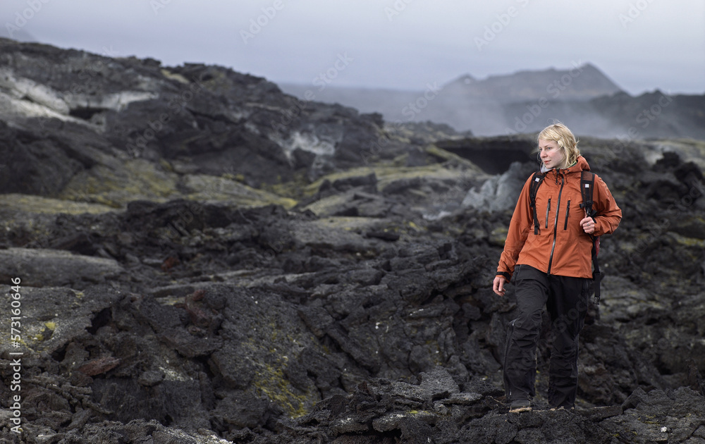 Woman hiking through lava field at the Krafla volcano / north Iceland Woman hiking through lava field at the Krafla volcano / north Iceland