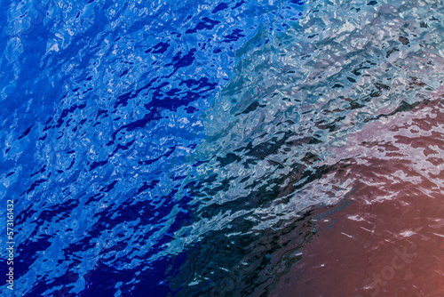 A view of the bulbous bow of a container ship underneath the surface of the ocean.