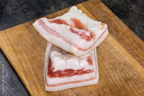 Pieces of salted pork fatback on cutting board, close-up