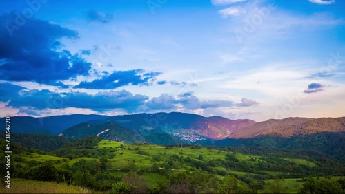 Multicolored sky with clouds and sunset light over the Rhodope Mountains with a intermountain village