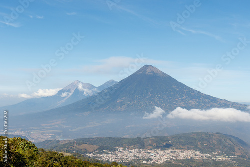 Pacaya Volcano hike tour. Panoramic view of volcano Fuego Acatenango and agua with village below