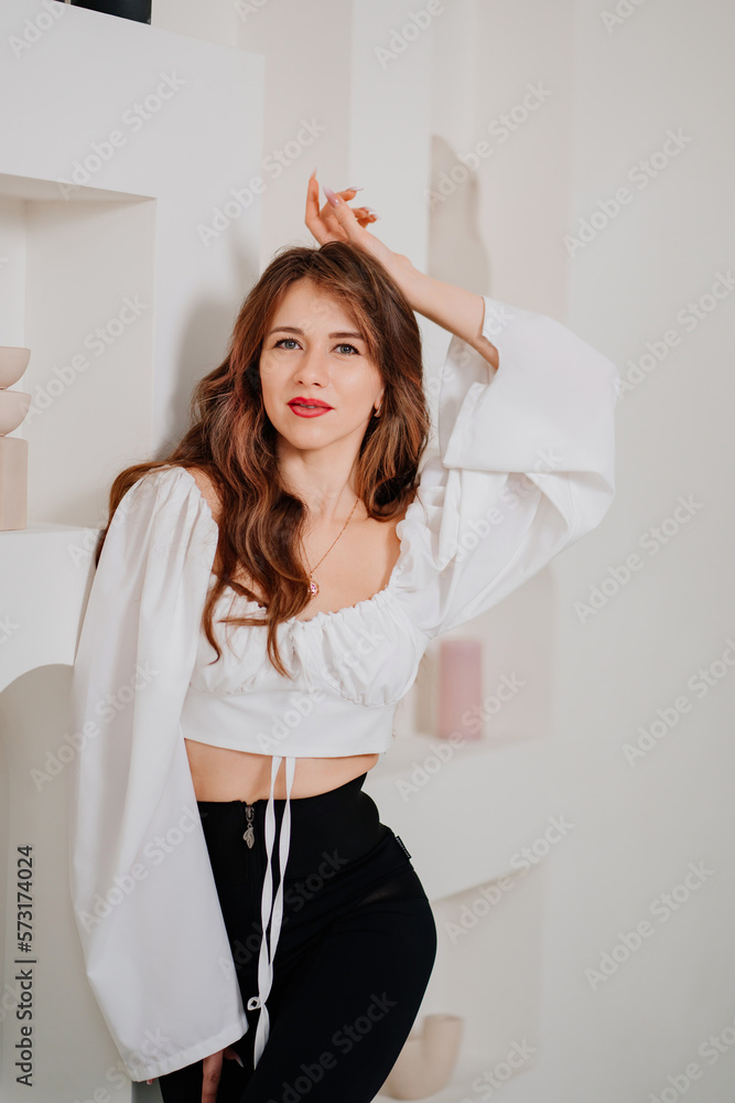 portrait of an attractive woman in a white romantic top with open shoulders.