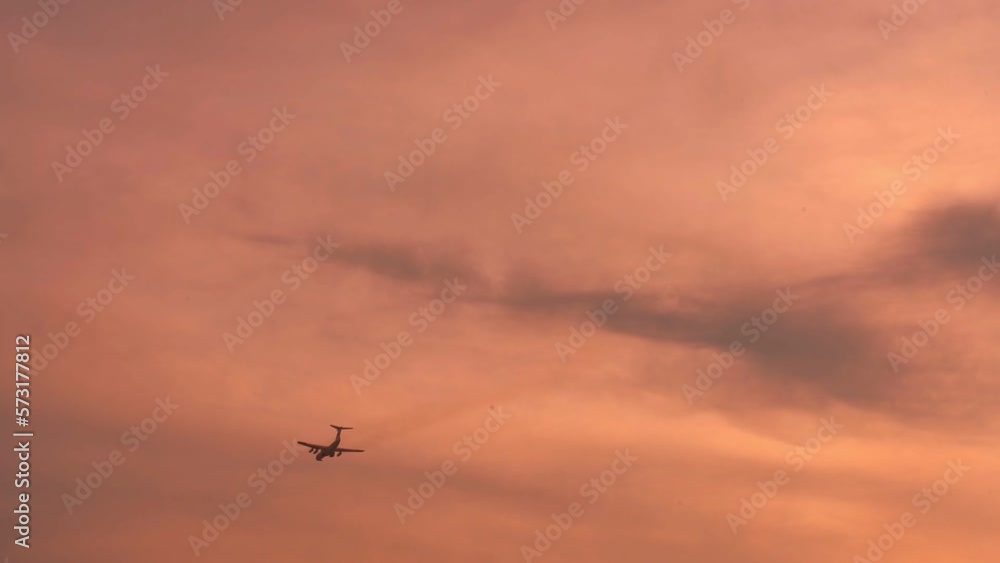 Passenger or cargo airplane floating across yellow sky at sunset. Delivery and vacation concept. Passenger or cargo airplane floating across yellow sky at sunset. Delivery and vacation concept.