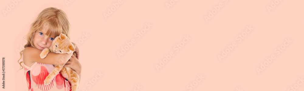 Cute sad girl hugging a little cat isolated on beige (Peach color) background Cute sad girl hugging a little cat isolated on beige (Peach color) background