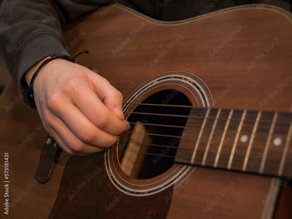Fototapeta premium Practice playing the acoustic guitar. Hands playing guitar and picking chords