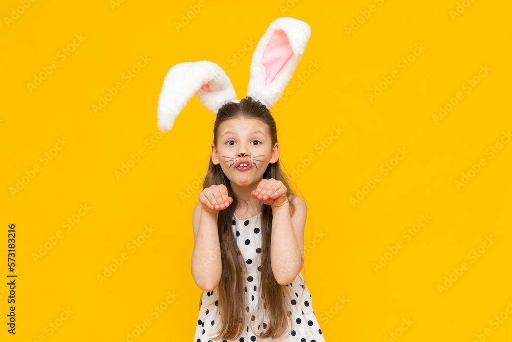 Cute attractive girl with Easter bunny ears gave a thumbs up, Easter day and egg coloring. international Easter holiday, spring holiday. A girl in a rabbit costume on a yellow isolated background. Cute attractive girl with Easter bunny ears gave a thumbs up, Easter day and egg coloring. international Easter holiday, spring holiday. A girl in a rabbit costume on a yellow isolated background.