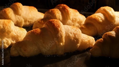 French croissants baking in oven. Timelapse of freshly baked croissants. Bakery concept. Yummy pastry. Homemade bakery. Breakfast. Delicious croissants rising up in oven. Close-up in 4K, UHD