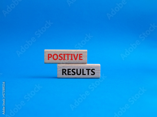 Positive results symbol. Concept words 'Positive results' on wooden blocks. Beautiful blue background. Business and Positive results concept. Copy space.