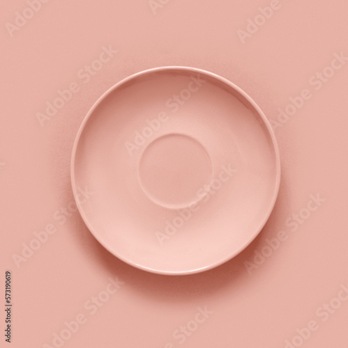 Peach color plates on peach table. Monochrome minimalistic image in hipster style.