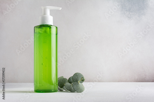 Transparent dispenser with green shampoo or shower gel photo