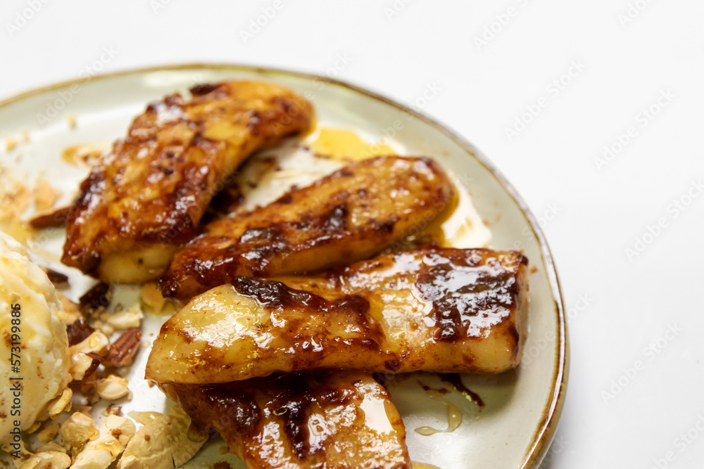 Pan-fried cinnamon bananas with ice-cream and crushed nut on top. Pan-fried cinnamon bananas with ice-cream and crushed nut on top.