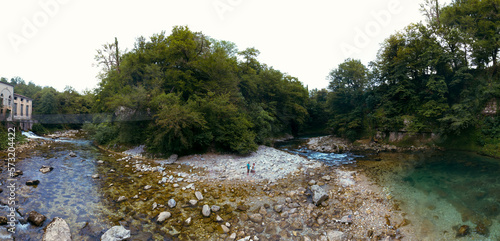 The Abhesi waterfall, couple tourists man and woman a mountain river with clear water. Tourist place for rest and swimming. Aerial wide panorama. western Georgia photo